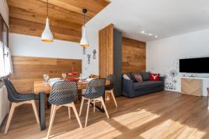 a dining room and living room with a table and chairs at Casa Caterina in Vigo di Fassa