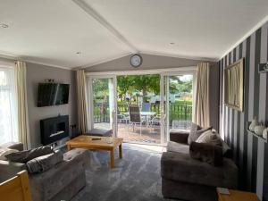 a living room with two couches and a table at Country Gem in Tydd Saint Giles