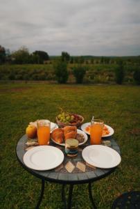 einen Tisch mit Teller mit Lebensmitteln und Gläsern Orangensaft in der Unterkunft Monte de Palma- Quinta Biodinâmica Momentos Únicos in Évora