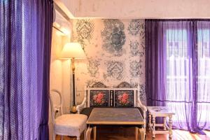 a bedroom with purple curtains and a bed with a table at Visionery apt in Pagrati in Athens