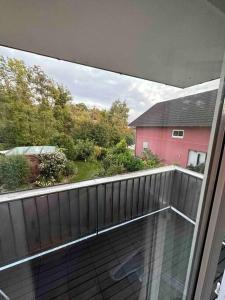 uma varanda com vista para uma casa rosa em Wohnung in Kressbronn am Bodensee em Kressbronn am Bodensee