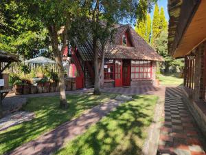 un petit bâtiment rouge avec des arbres dans la cour dans l'établissement Tu Casa - Hotel Rural, à Sopó