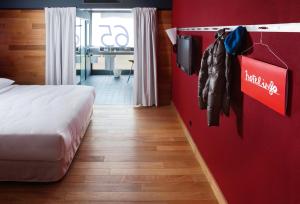 a hotel room with a bed and a red wall at Casa Camper Berlin in Berlin