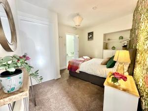 a bedroom with a bed and a table with a lamp at Blossoms Reach - 2 minutes from station and city centre in York