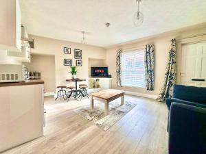 a living room with a table and a kitchen at Blossoms Reach - 2 minutes from station and city centre in York