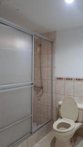 y baño con aseo y cabina de ducha. en Venecia Hotel Larco, en Trujillo