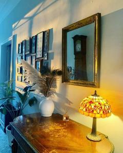 Rouffignac-de-SigoulèsにあるChâteau Le Repos - Luxury air-conditioned property with poolの鏡付きテーブルの上のランプ