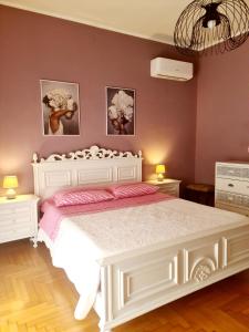 a bedroom with a white bed and two night stands at V.home in Abano Terme