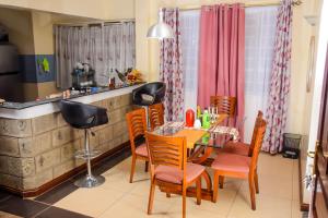 een keuken en eetkamer met een tafel en stoelen bij The Penthouse Suites Serviced Apartments Meru in Meru