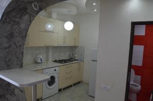 cocina con fregadero y lavadora en Irakli's Apartment with Sea view, en Batumi