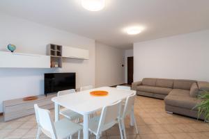 uma sala de estar com uma mesa e cadeiras brancas e um sofá em Mizar*Q-Ampio Quadrilocale ad uso privato em Foligno
