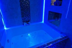 a bath tub with blue lighting in a bathroom at Aphrodite Suites Huddersfield in Huddersfield