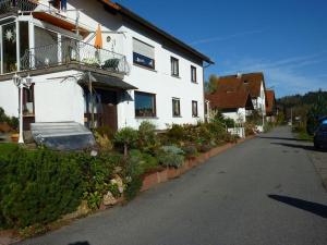 Casa blanca con balcón en una calle en Ferienwohnung Koenig, en Wald-Michelbach