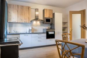 a kitchen with white appliances and wooden cabinets at Ferienhaus Weingut Plonerhof in Bolzano