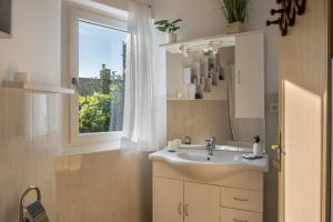 bagno con lavandino e finestra di Ferienhaus Weingut Plonerhof a Bolzano