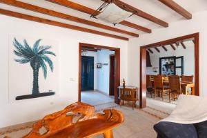 a living room with a palm tree painting on the wall at Casa Melián in Playa Blanca