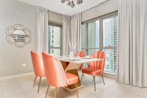 a dining room with a table and orange chairs at BellaVista Boulevard Central Spacious 2 Bedroom with maids room Burj Khalifa and Fountain View in Dubai