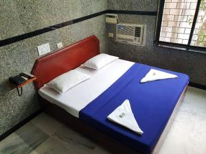 a bedroom with a bed with a blue and white blanket at HOTEL GREENS - Puratchi Thalaivar Dr M G Ramachandran Central Railway Station Chennai in Chennai
