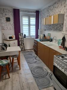 a kitchen with a sink and a stove top oven at Apartament LORD in Toruń