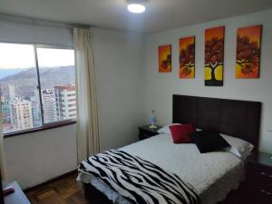 1 dormitorio con cama y ventana grande en APARTAMENTO PRIVADO Piso 20a, CENTRICO, CERCA EMBAJADA USA, TELEFERICO, MALLS, VISTAS 360 y ZONA SEGURA en La Paz