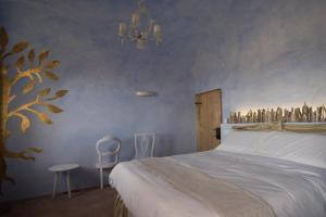 a bedroom with a bed and a chandelier at B&B La Pecora Nera in Mazzolla