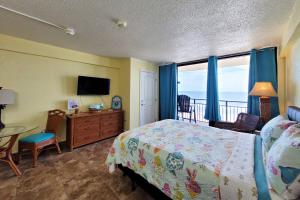 - une chambre avec un lit, un bureau et une télévision dans l'établissement Beach Condo Unit #435, à Daytona Beach Shores