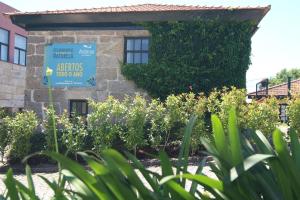un panneau devant un bâtiment avec des plantes dans l'établissement Aldeia do Tâmega, à Amarante
