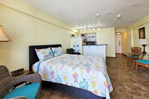 Cet appartement comprend une chambre avec un lit, une cuisine et une table. dans l'établissement Beach Condo Unit #435, à Daytona Beach Shores