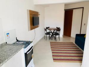 a kitchen with a stove and a table with chairs at Recanto da paz in Arraial do Cabo +4 photos