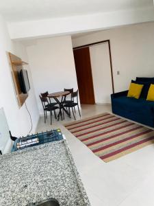 a living room with a blue couch and a table at Recanto da paz in Arraial do Cabo