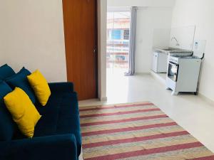 a living room with a blue couch and a kitchen at Recanto da paz in Arraial do Cabo