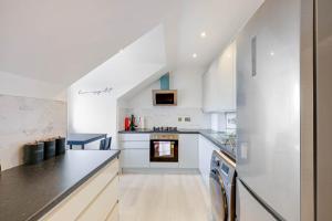 a kitchen with white cabinets and a counter top at Modern, Bright, Spacious 2 Bed 2 Bath Barnet Penthouse By 360Stays in Barnet