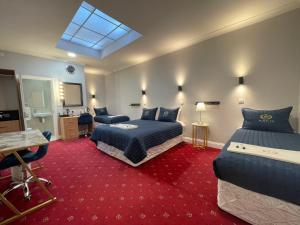 a hotel room with two beds and a television at Jubilee Hotel Victoria in London