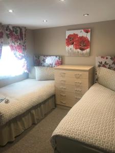 a bedroom with two twin beds and a dresser at 3 Bedroom Self-Catering Holiday Home in Steps