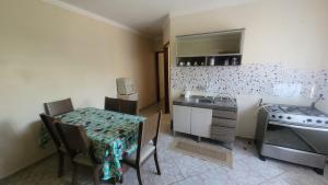 a kitchen with a table and a sink and a stove at Casa Feliz in Cascavel