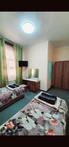 a large room with two beds and a desk at HOTEL APOLLON in Samarkand