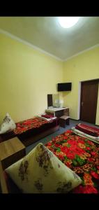 a hotel room with two beds and a television at HOTEL APOLLON in Samarkand +3 photos