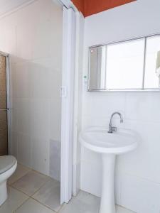 a white bathroom with a sink and a toilet at Pousada Caldas Novas in Caldas Novas