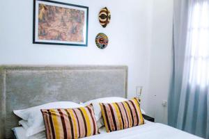 a bed with two pillows and a picture on the wall at Killi Luxury Villa in Moshi