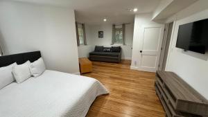 a bedroom with a bed and a couch and a television at Perrin Place Unit 1 in Boston