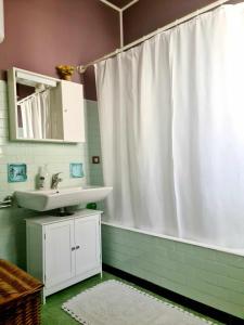 łazienka z białą zasłoną prysznicową i umywalką w obiekcie V.home w mieście Abano Terme