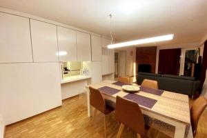cocina y comedor con mesa y sillas en Cosy 4.5 rooms apartment @ LS 16 Dübendorf, en Dübendorf