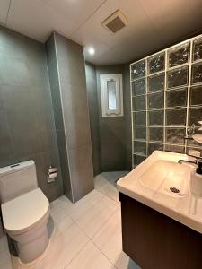 a bathroom with a toilet and a sink and a shower at Kama Place in Muscat