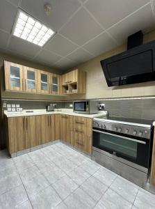 a large kitchen with wooden cabinets and a stove at Kama Place in Muscat