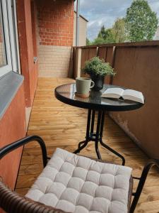 una mesa y una silla en un balcón con un libro en Rauna Apartment NR 8, en Rauna