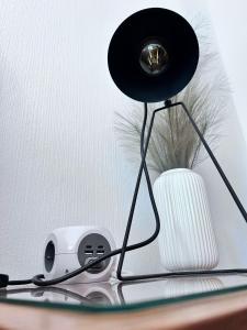 a lamp and a speaker on a table with a fan at aPARTMENT KARL 22 in Alsfeld