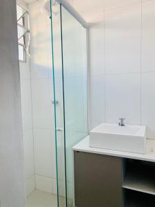 a bathroom with a sink and a glass shower at Recanto da paz in Arraial do Cabo