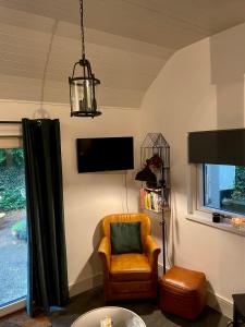a living room with a chair and a tv at Railway cottage Annascaul in Anascaul