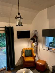 a living room with a chair and a tv at Railway cottage Annascaul in Annascaul