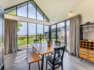 a dining room with a table and chairs and large windows at Shearwater Lodge in Bamburgh +23 photos